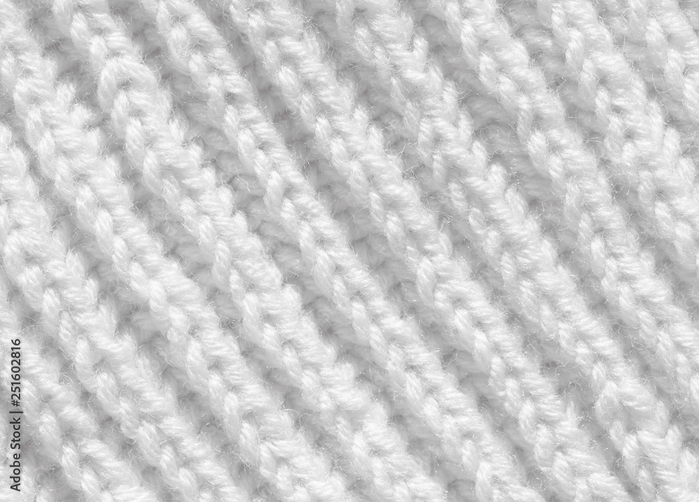 The background is white. The texture of the knitted fabric is made of woolen threads handmade. The background is white. The texture of the knitted fabric is made of woolen threads handmade.