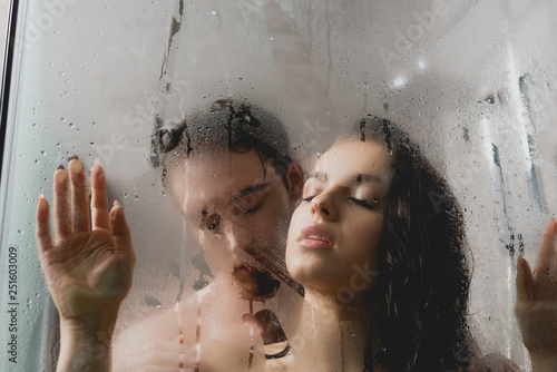 Fototapeta selective focus of hot naked man and attractive woman hugging in shower cabin