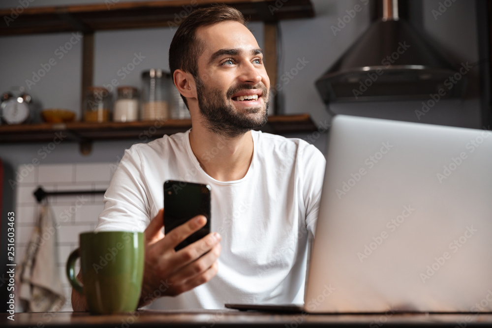 Happy young man using laptop computer