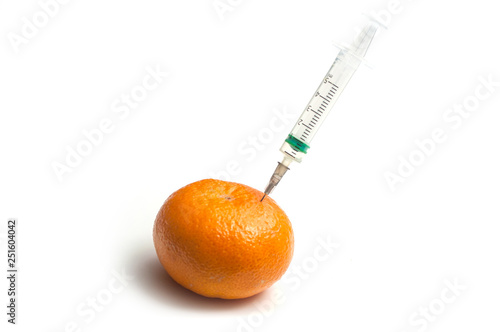 closeup of injecting with a syringe into a tangerine on white background