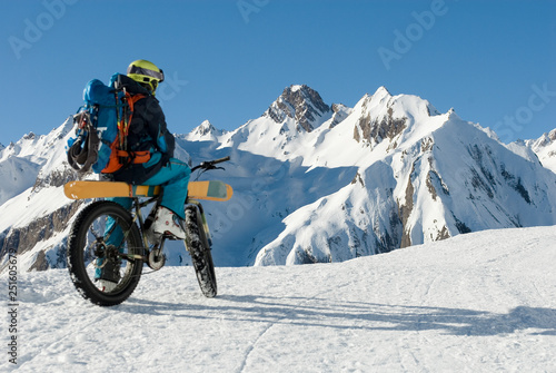 man with an electric bike, e-bike, ebike, mountains of Formazza Valley, ski loaded on bicycle, on path with snow and continue with skis, winter, sport, adventure, travel, Alps, Piedmont, italy