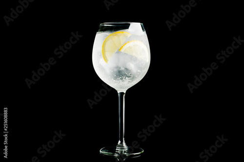 Gin based cocktail in wine glass isolated on black background. Selective focus. Shallow depth of field.