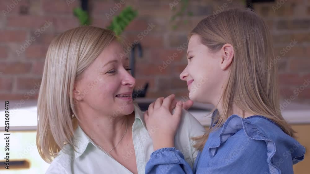 trust mother, little happy daughter tells beloved mom whispering secrets in ear close up at home trust mother, little happy daughter tells beloved mom whispering secrets in ear close up at home