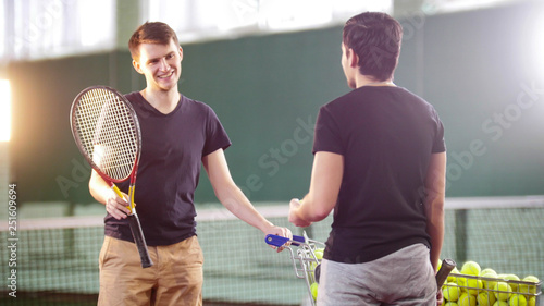 Training on the tennis court. Young men talking