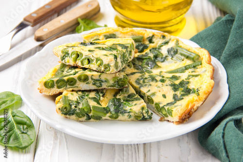 Omelet with spinach and green beans, healthy food. Egg and milk Frittata, delicious Breakfast on white wooden background