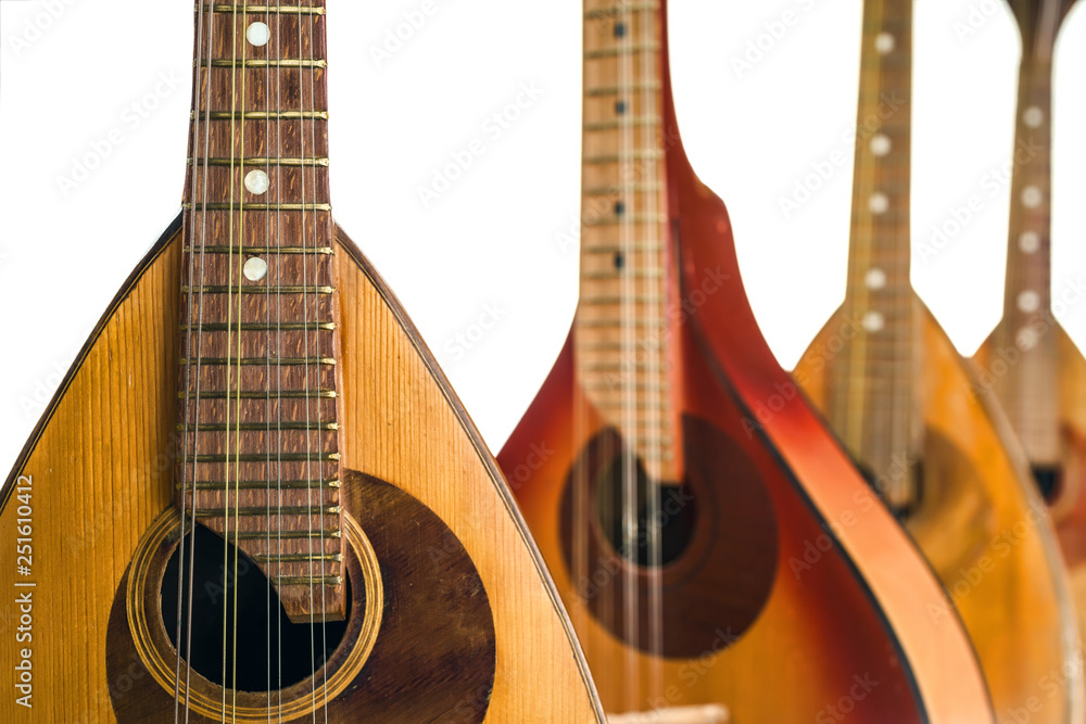 Four mandolins close up. Isolated on a white background. Selective focus.
