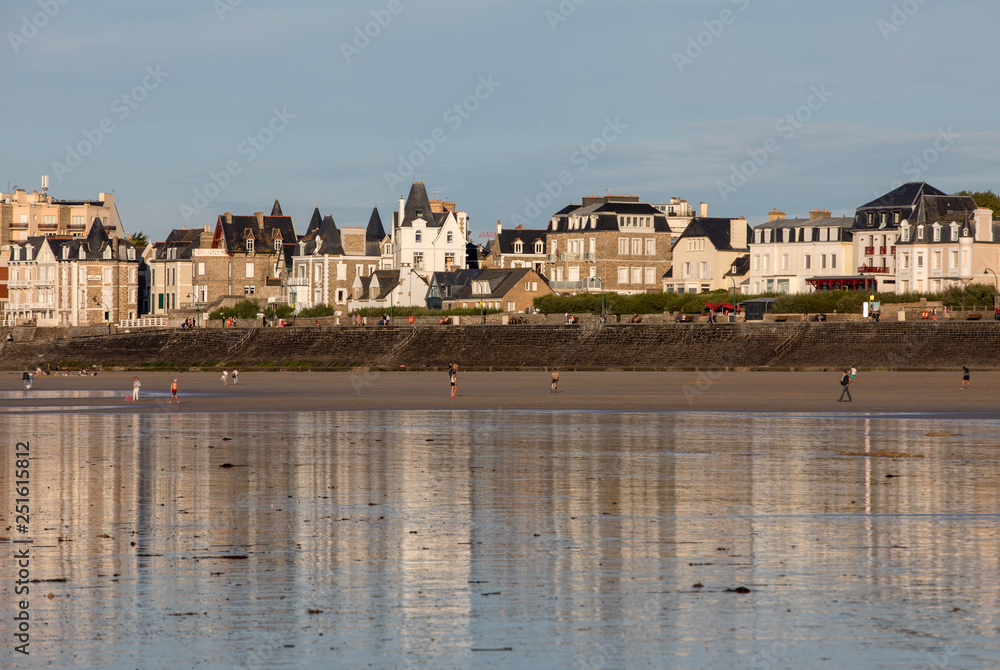 Beach in the evening sun and buildings along the seafront promenade in Saint Malo. Brittany, France