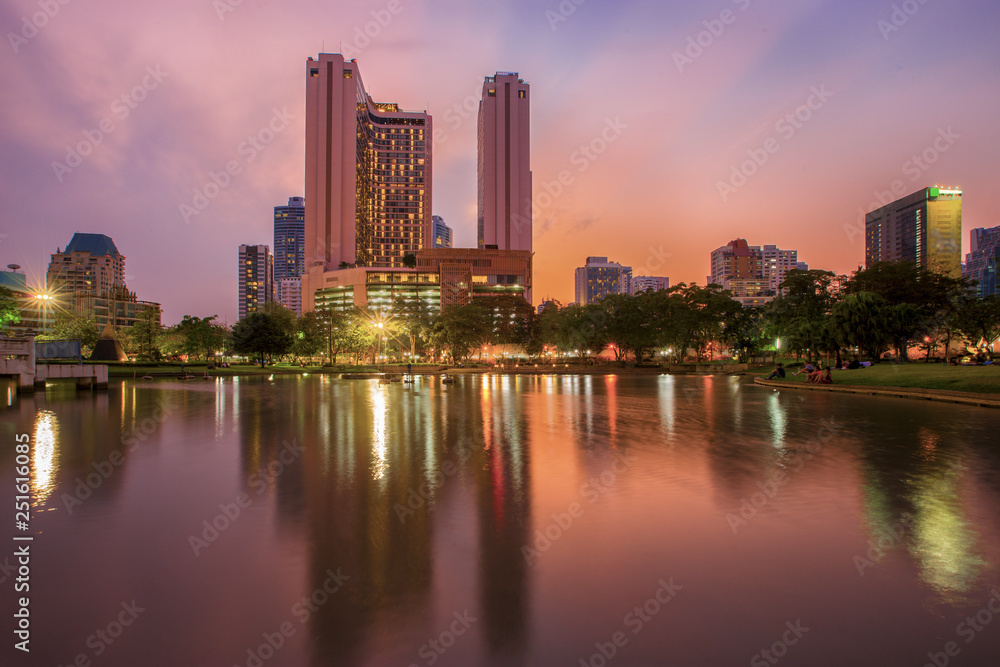 Bangkok business district with the public park area in the foreground at sunset time