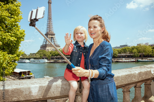 mother and daughter tourists taking selfie using selfie stick photo