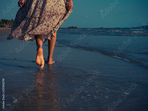 Women wearing vintage dresses are walking on the beach with excitement to relax. Summer beach trips are very good.