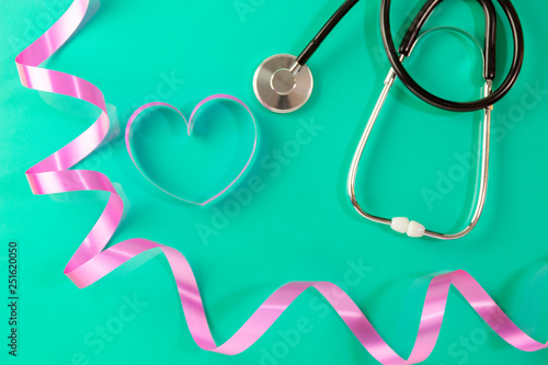 World health day background,Stethoscope and pink ribbon heart on green background,Concept healthcare and medical background