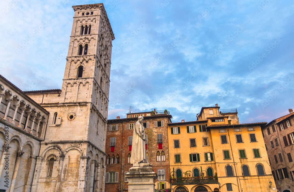 Bell tower of Chiesa di San Michele in Foro St Michael Roman Catholic church and monument in historical centre of old medieval town Lucca, evening view, cloudy blue sky background, Tuscany, Italy