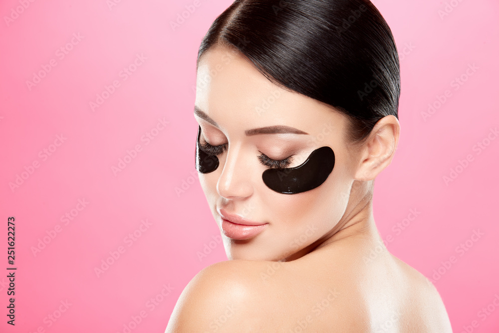 Young girl with nude make up and naked shoulders at studio background,black eye patches on face, beauty photo concept, copy space. Young girl with nude make up and naked shoulders at studio background,black eye patches on face, beauty photo concept, copy space.