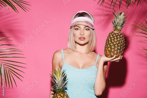 Girl in swimwear at pink studio background