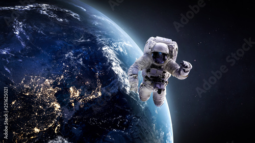 Nightly Earth and astronaut in the outer space. Abstract wallpaper. City lights on planet. Spaceman. Elements of this image furnished by NASA photo