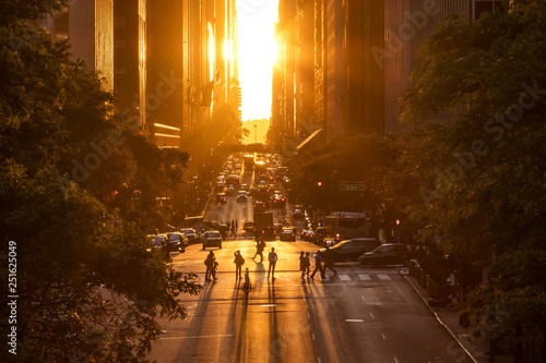 Rays of sunlight shining down on the people and traffic at the intersections along 42nd Street through Midtown Manhattan in New York City photo