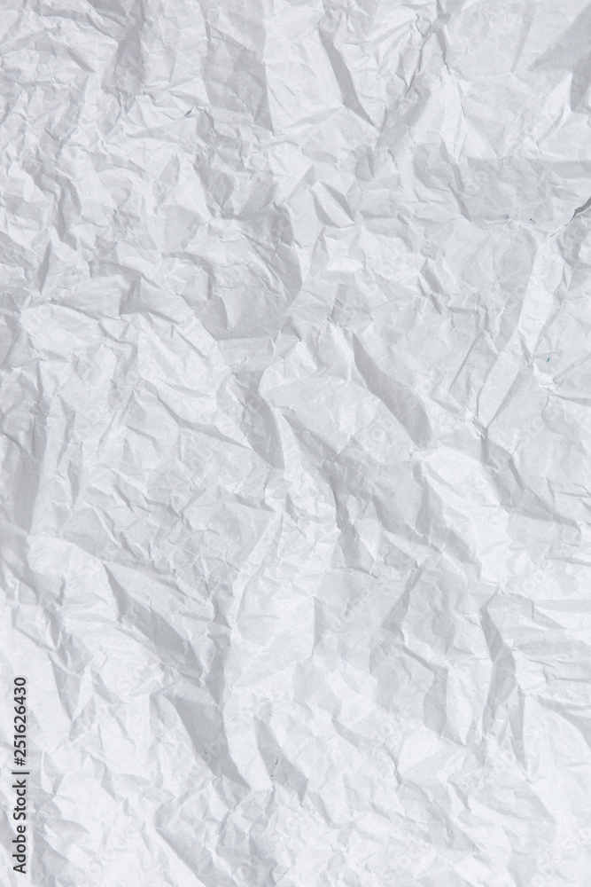 Crumpled paper texture. White battered paper background. White empty leaf of crumpled paper. Torn surface of letter blank. Copy space
