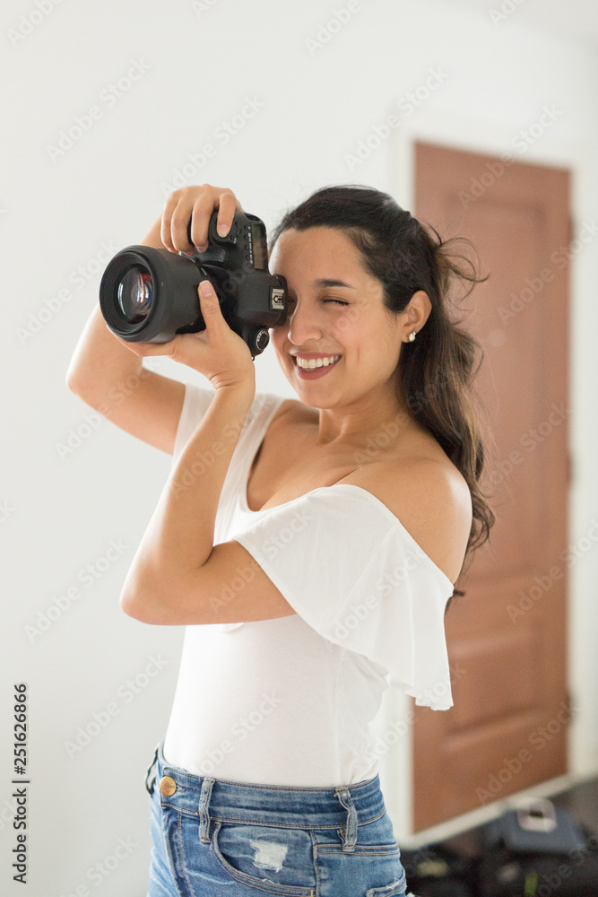 Smiling female photographer taking picture with camera Smiling female photographer taking picture with camera