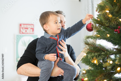 Father and son decorating Christmas tree at home