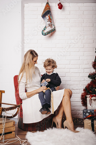 Mother and son sitting on chair at home during Christmas