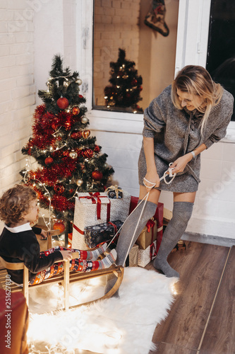Smiling mother and son playing at home during Christmas