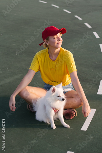 Woman with dog sitting on road
