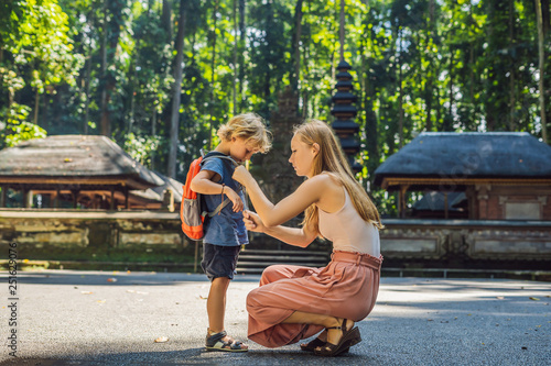 Mom and son travelers discovering Ubud forest in Monkey forest, Bali Indonesia. Traveling with children concept photo