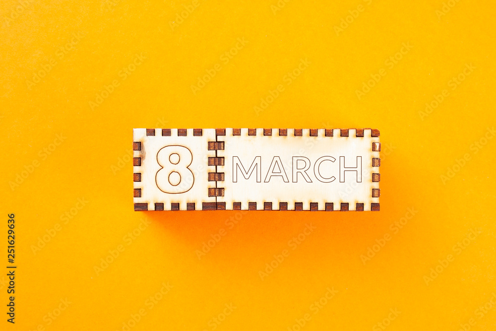 Fototapeta premium wooden cubes with the inscription March 8 on orange background. 8 march and women day concept