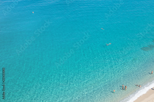 Tropea, Calabria, Italy - September 12, 2018: Top view of the beautiful endless azure sea with a small fragment of a sandy beach. © Mikhail Pankov