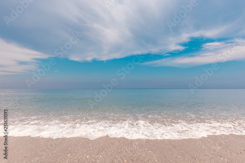 Idyllic seascape with surf line and beautiful clouds over sea. The sea foam at coastal line. Summer paradise beach. © stone36