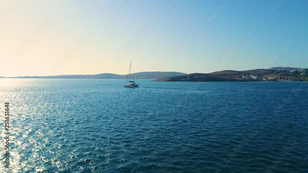 Small ship floats on water with mountains on background Small ship floats on water with mountains on background