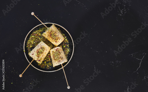 Saffron pistachio cream kulfi, traditional Indian dessert, ready to eat. Top view, blank space photo