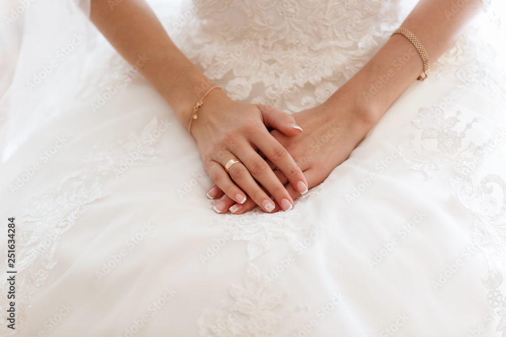 cropped photo close up the bride sitting on a chair in a networked white dressing gown. hands lie on the knees. morning of the bride cropped photo close up the bride sitting on a chair in a networked white dressing gown. hands lie on the knees. morning of the bride