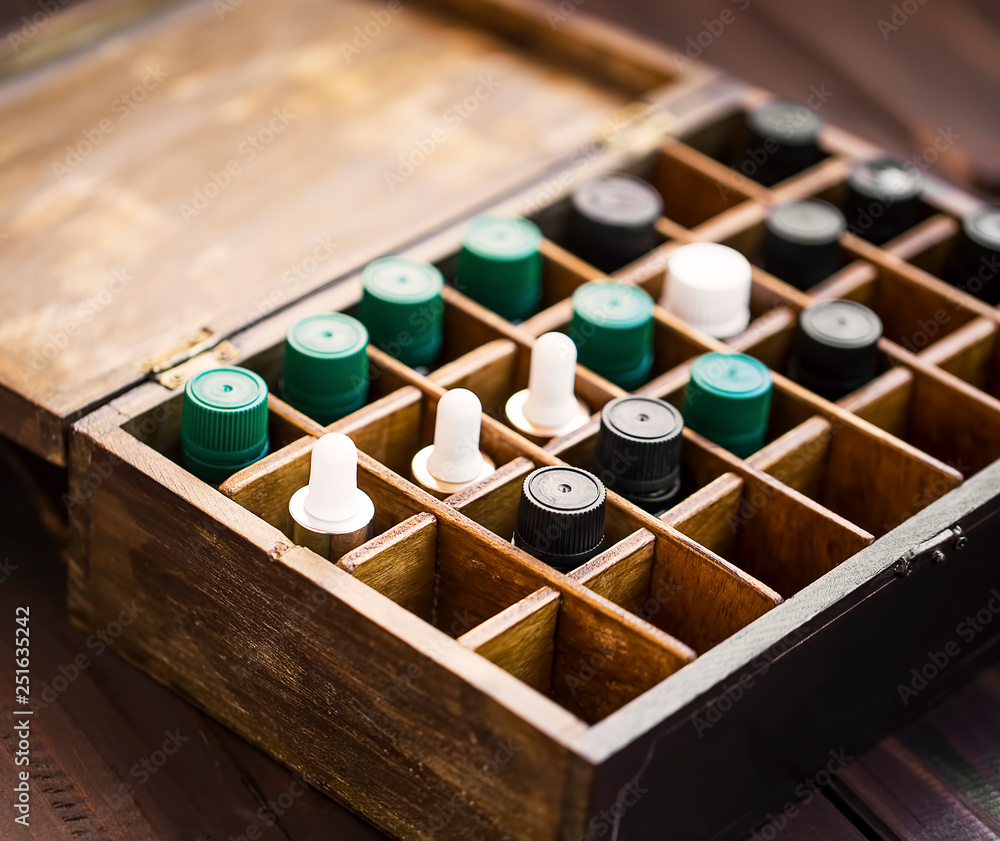 Aromatherapy essential oils in wooden box. Herbal alternative medicine with essential oils bottles in wooden box, healthy organic natural therapy Aromatherapy essential oils in wooden box. Herbal alternative medicine with essential oils bottles in wooden box, healthy organic natural therapy
