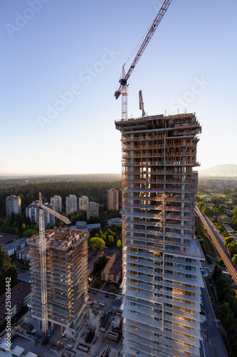 Aerial view of a residential building construction site during a vibrant summer sunset. Taken in Burnaby, Vancouver, BC, Canada. photo