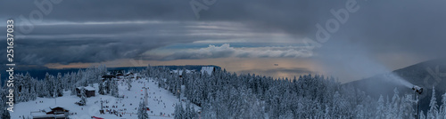 Panoramic view of Grouse Mountain Ski Resort during a cloudy winter sunset. Taken in North Vancouver, British Columbia, Canada.