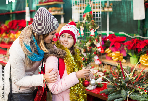 Woman with daughter looking at floral decoration at Cristmas fair