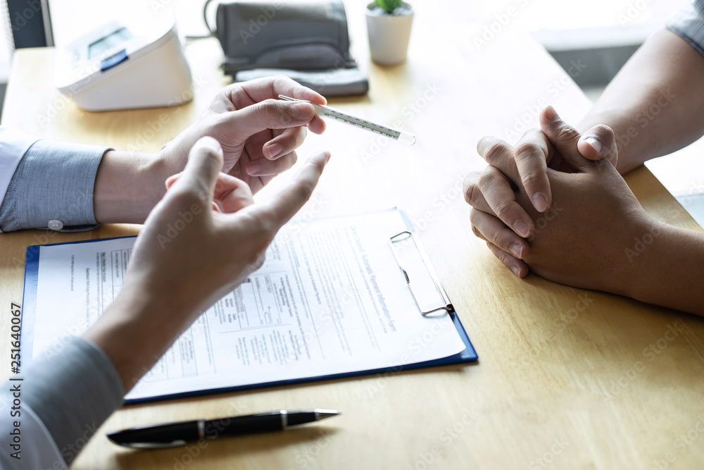 Doctor consulting with patient examining for patient, presenting results symptom for using thermometer and recommend treatment method, Healthcare and medical concept Doctor consulting with patient examining for patient, presenting results symptom for using thermometer and recommend treatment method, Healthcare and medical concept