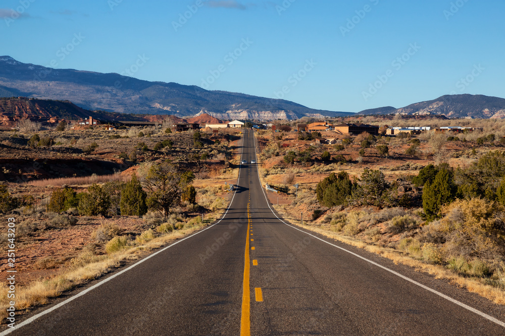 Scenic road in the desert during a vibrant sunny sunrise. Taken on Route 24 near Torrey, Utah, United States of America.