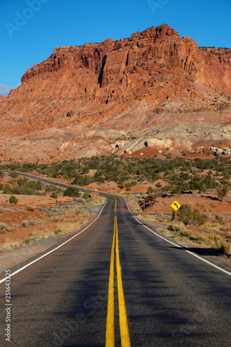 Scenic road in the desert during a vibrant sunny sunrise. Taken on Route 24 near Torrey, Utah, United States of America.