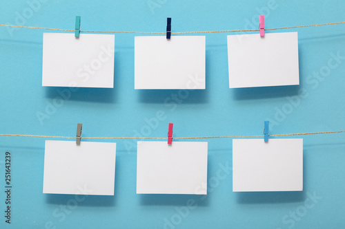 place for photo cards of moments of life, empty blanks attached to a linen rope with stationery clips on a colored background, a concept template for text, images, idea for home decor