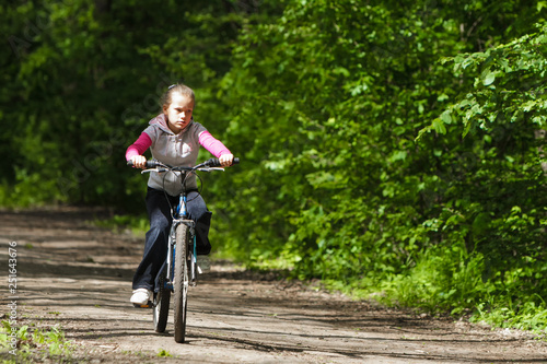 Fototapeta Naklejka Na Ścianę i Meble -  Girl on a bike in the forest