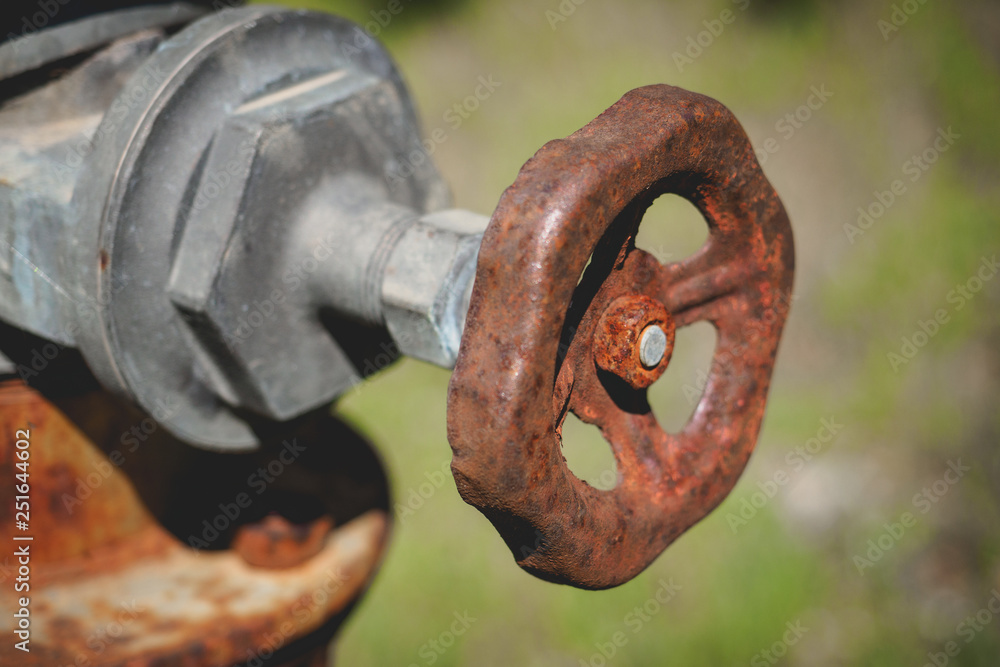 Close-up of a rusty tap valve on an old water pump.