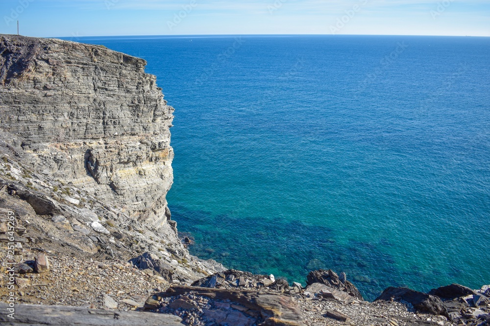 Grey cliffs rise sharply from the turquoise water of the mediterranean along the rocky coastline of southern spain.  