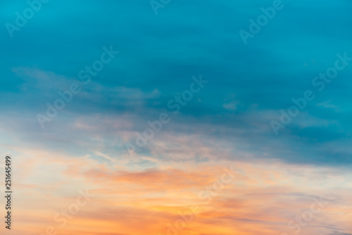 Fototapeta Naklejka Na Ścianę i Meble -  Sunset sky with orange yellow light clouds. Colorful smooth blue sky gradient. Natural background of sunrise. Amazing heaven at morning. Slightly cloudy evening atmosphere. Wonderful weather on dawn.