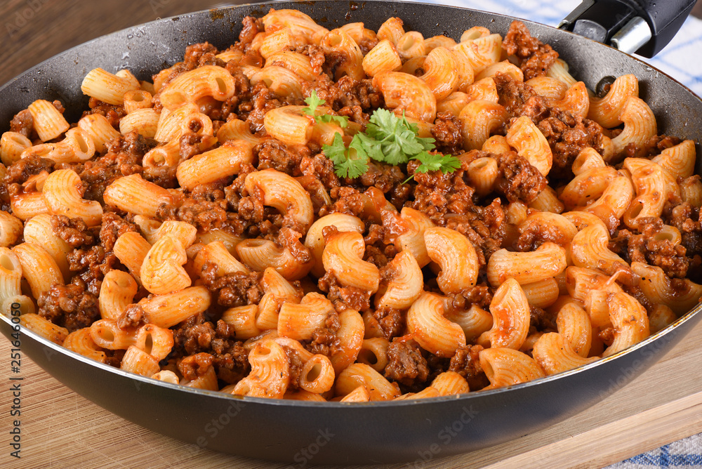 Pasta with ground beef and tomato paste in a pan. Pasta with ground beef and tomato paste in a pan.