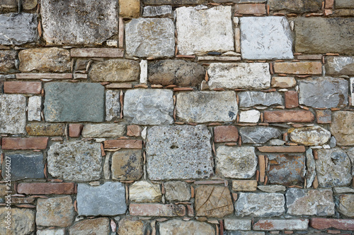 Squared stone masonry background with white, red, grey and black stones. Landscape format.