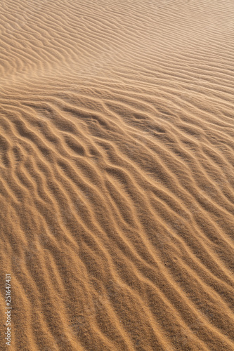 Amazing abstract background image of ripples and waves in the sand at sunrise