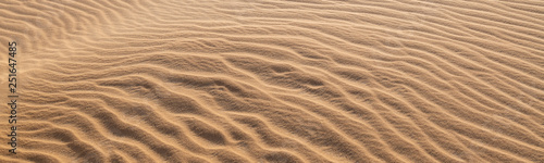 Amazing abstract background image of ripples and waves in the sand at sunrise