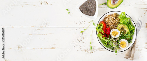 Fresh salad. Breakfast bowl with oatmeal, paprika, avocado, lettuce, microgreens and boiled egg. Healthy food. Vegetarian buddha bowl. Top view. Banner